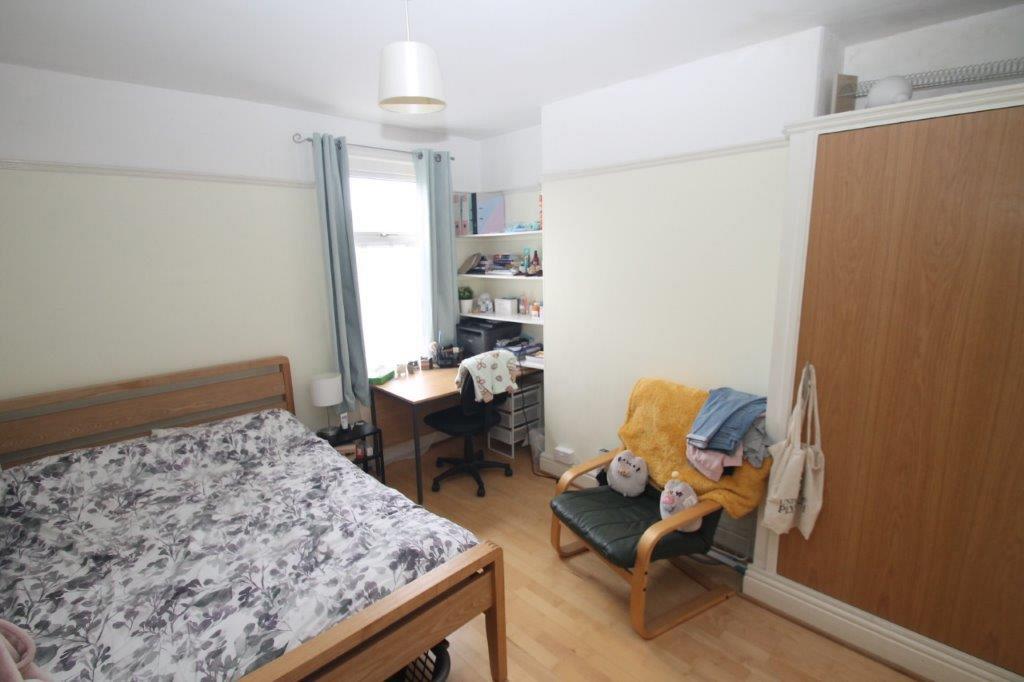Second student bedroom with double bed, built-in wardrobe and desk