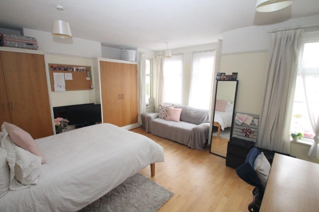 First student bedroom with a double bed, desk, two seater soda and two built-in wardrobes