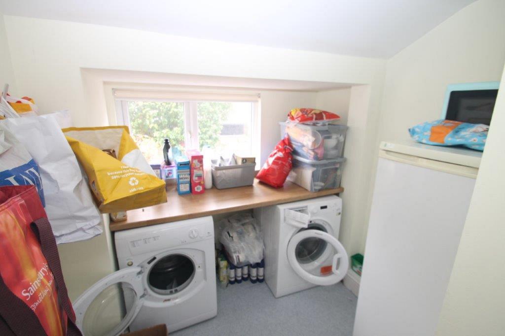Utility room with washing machine, tumblr dryer and freezer