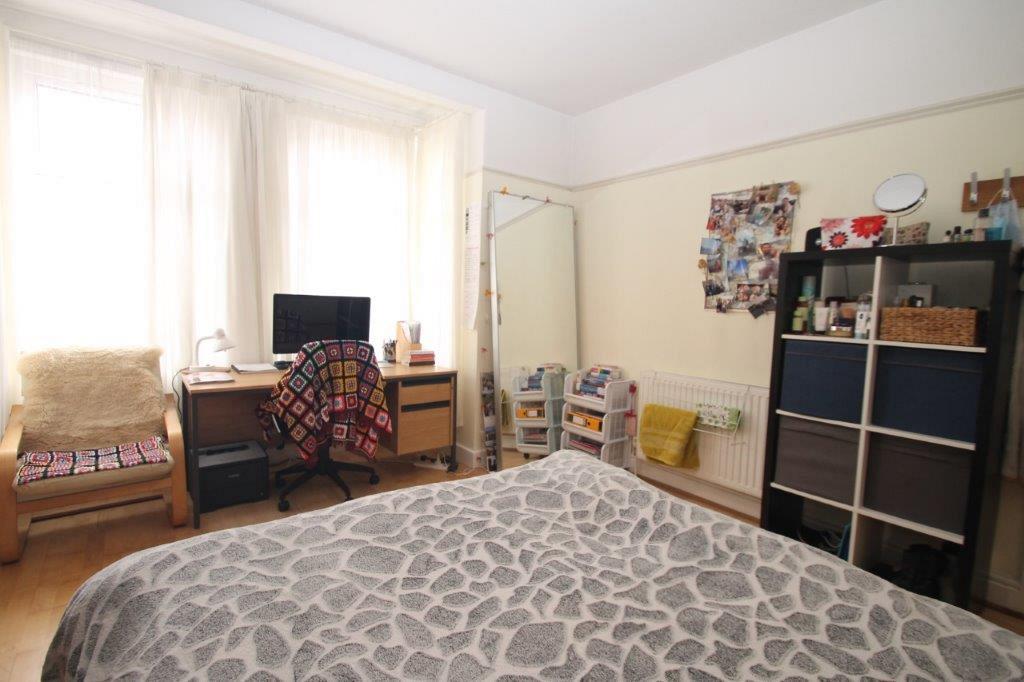 Student bedroom with double bed, desk and shelving unit