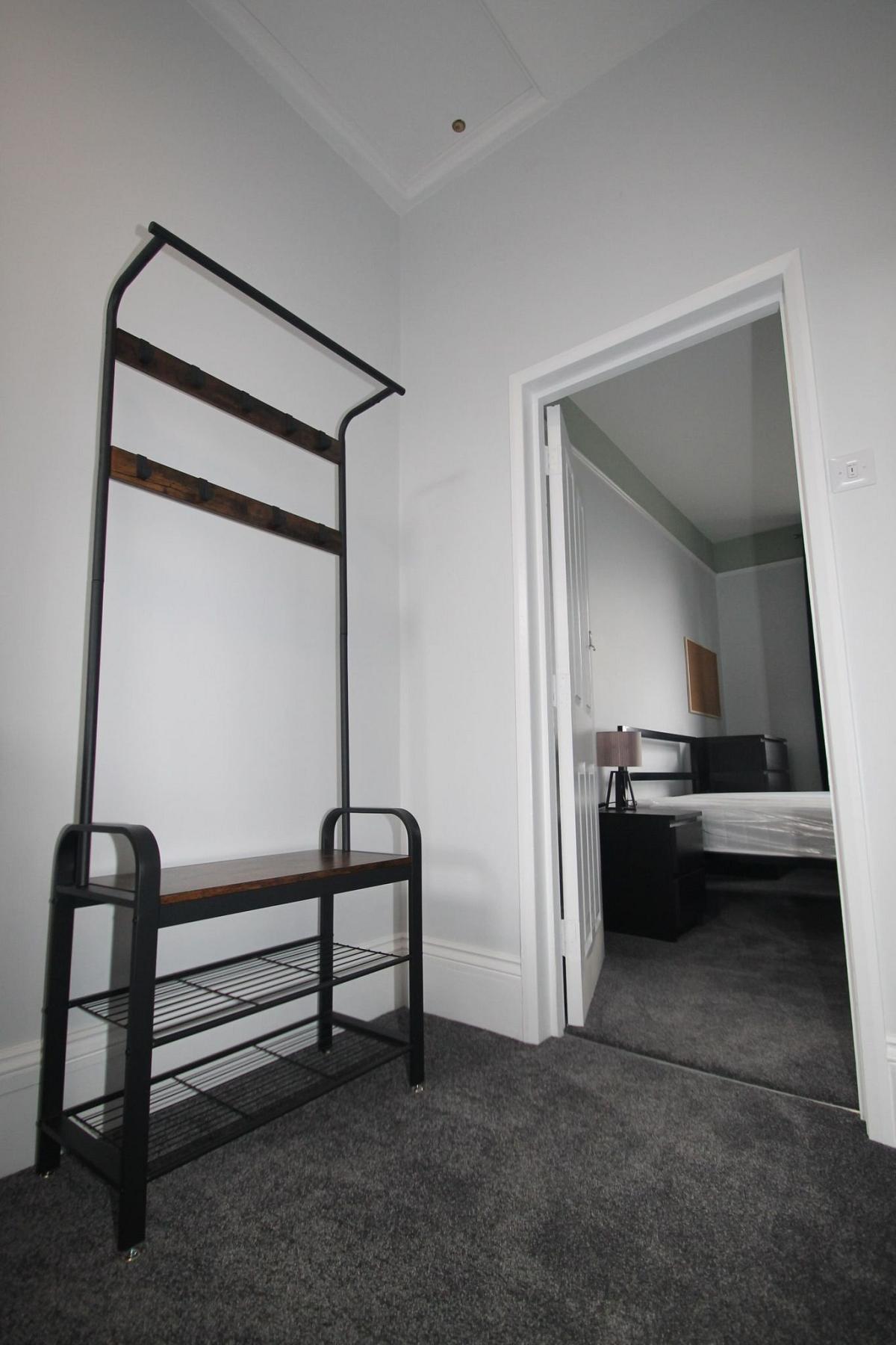 Hallway with coat rail, leading into student bedroom