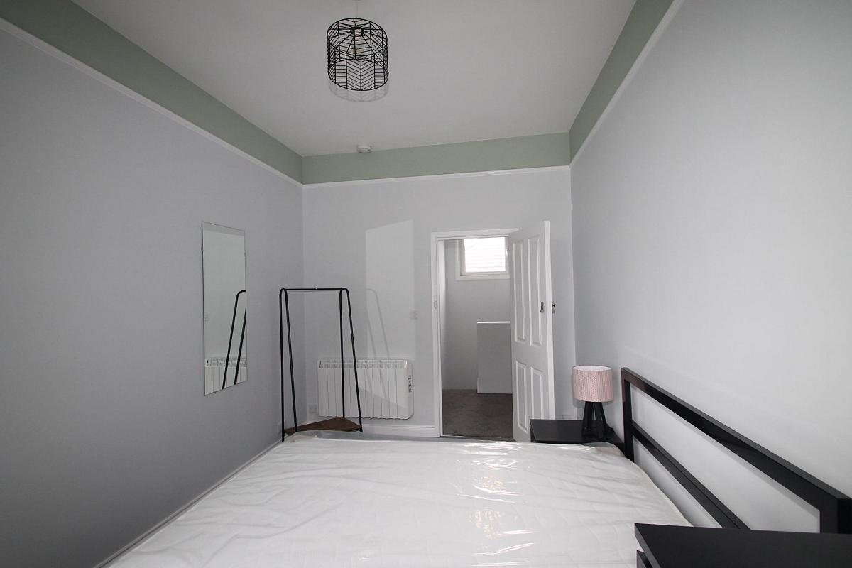 Student bedroom with double bed, clothes rail and full length mirror