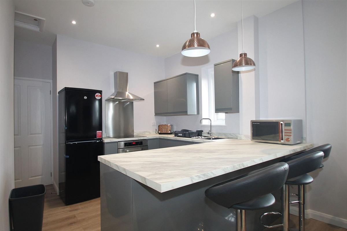 Shared kitchen with fridge freezer, hob and cooker with breakfast bar