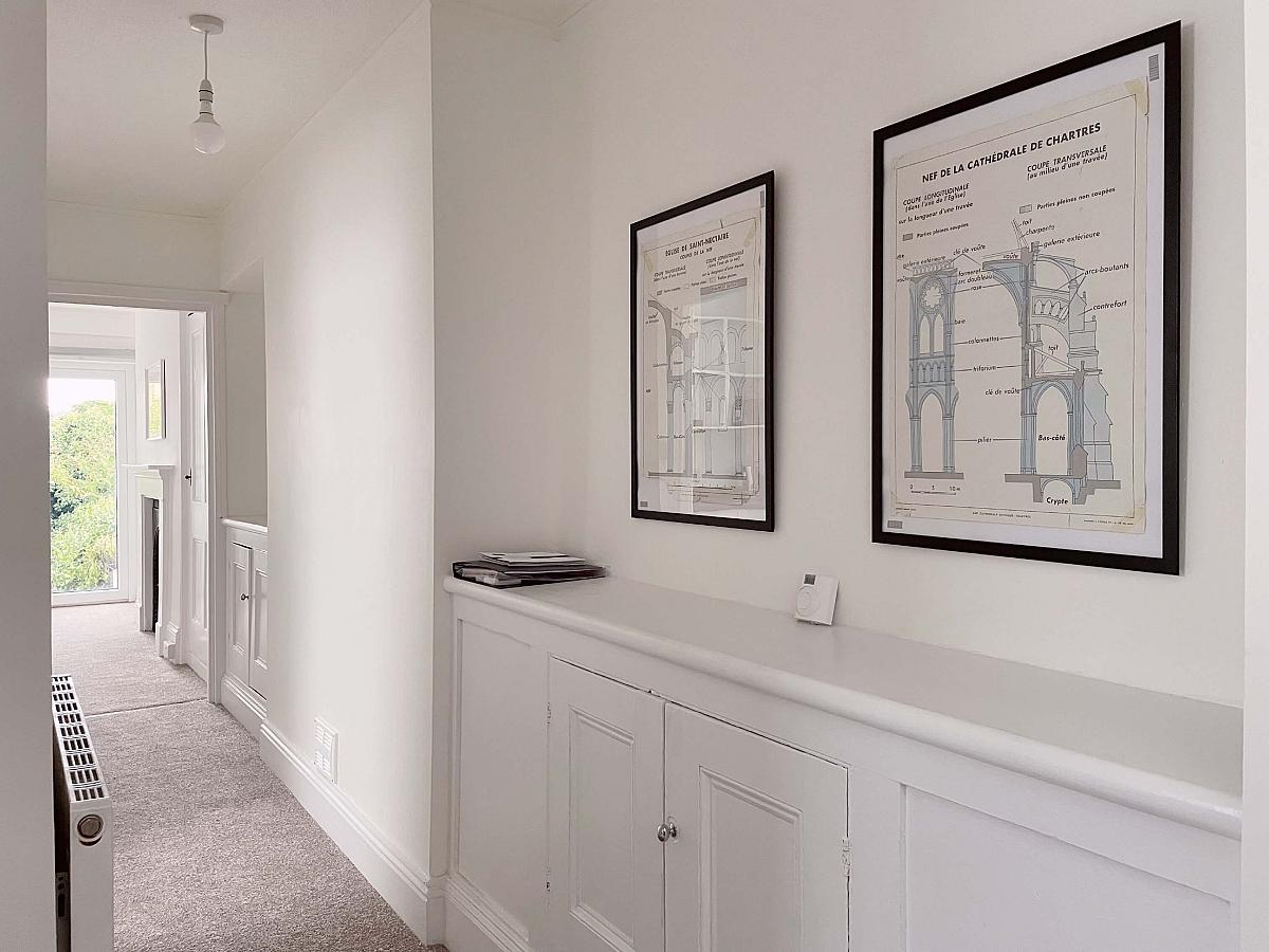 Hallway in the property leading to the living room with storage cupboard along wall