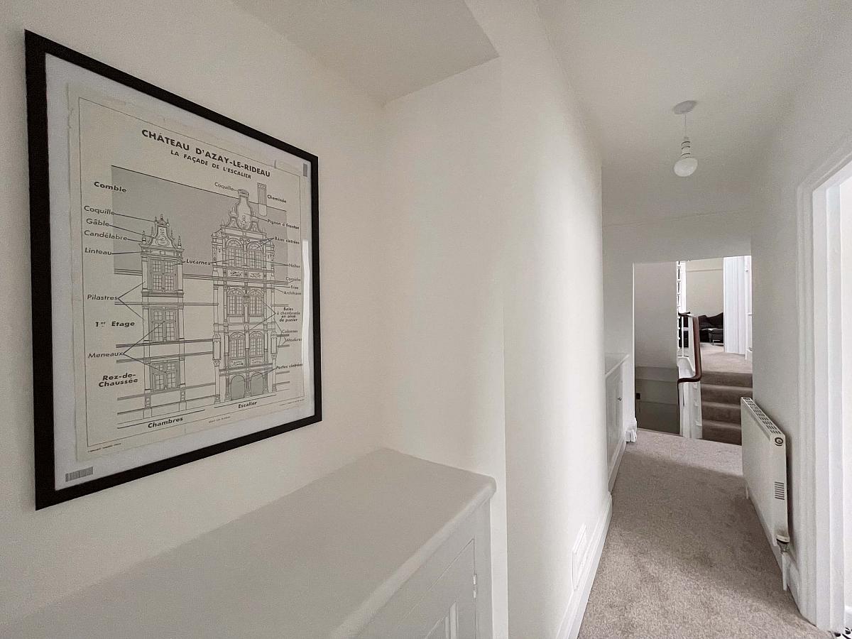 Hallway of property showing entrance to property and stairwell to living space