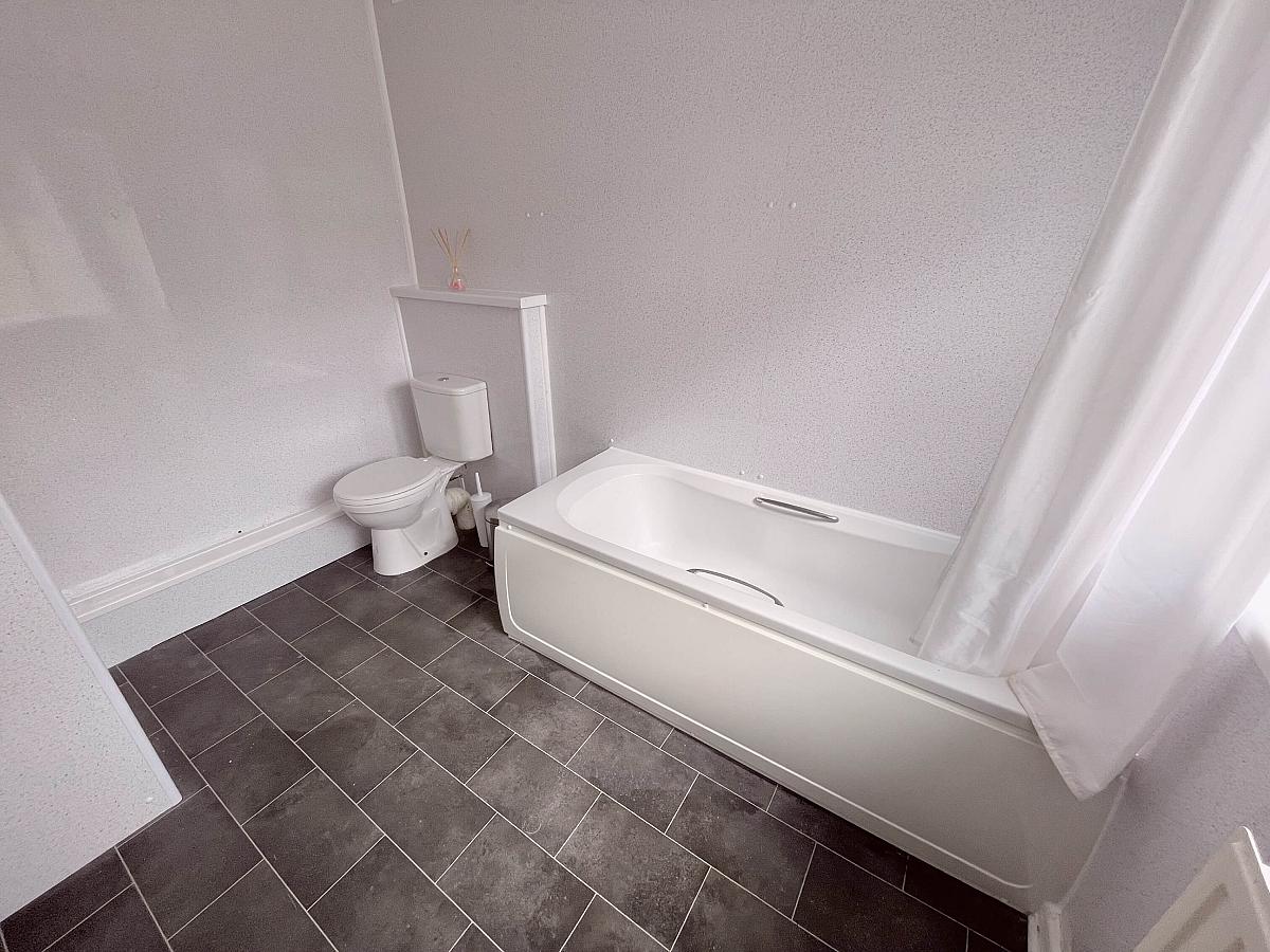 Shared bathroom with bath and shower head