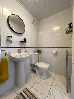 shared bathroom with circular mirror above sink