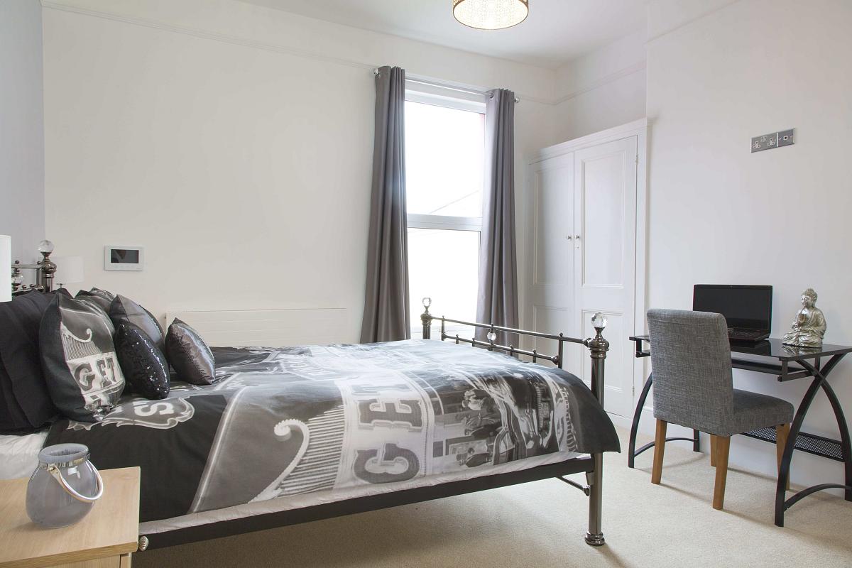 First student bedroom with double bed, desk and two door built-in wardrobe