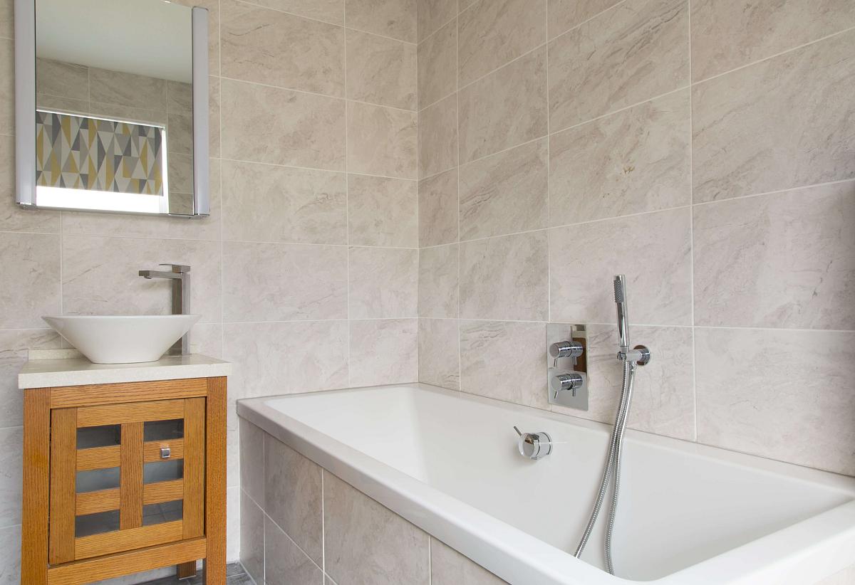 Shared bathroom with large bathtub and sink