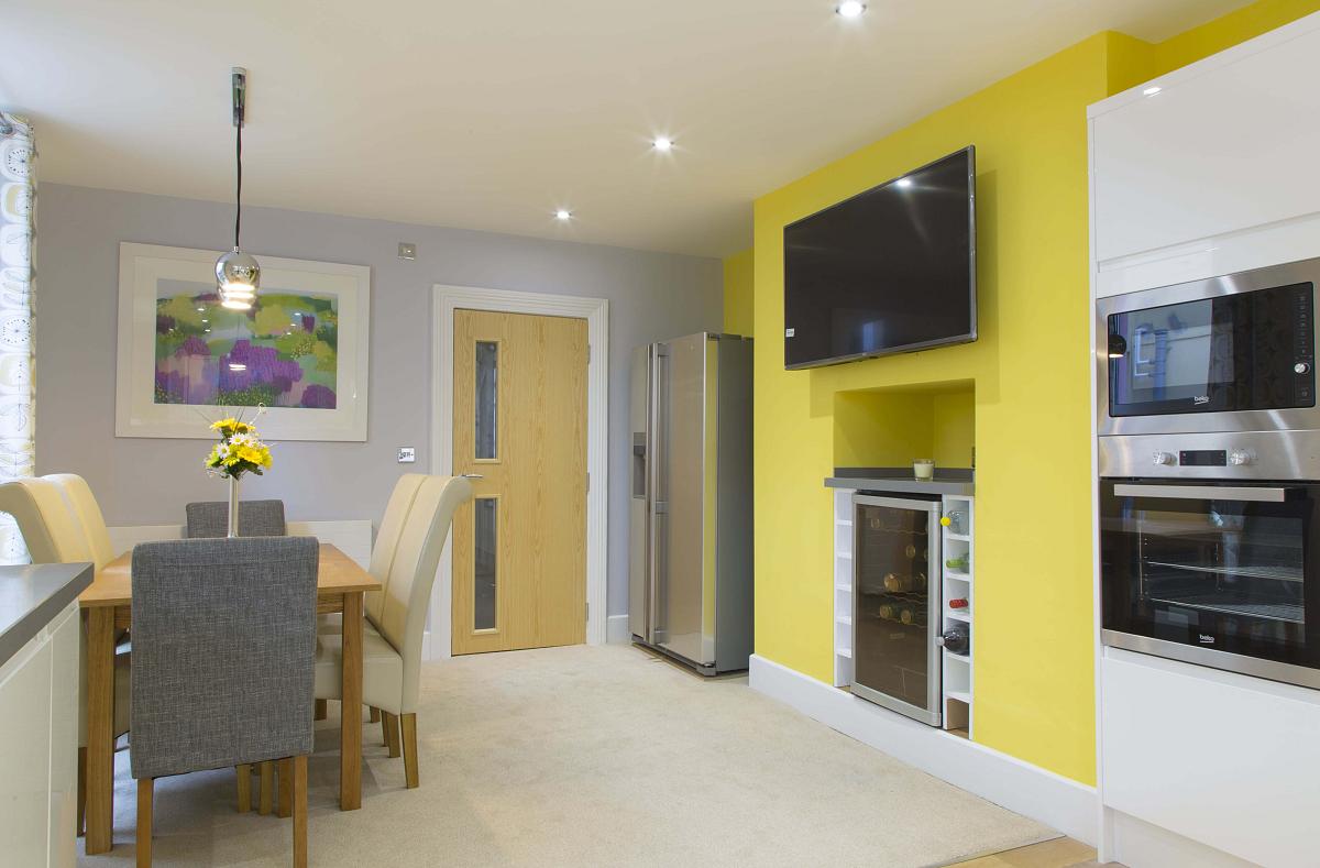 Shared kitchen and dining area with double door fridge freezer, two cookers and drinks fridge