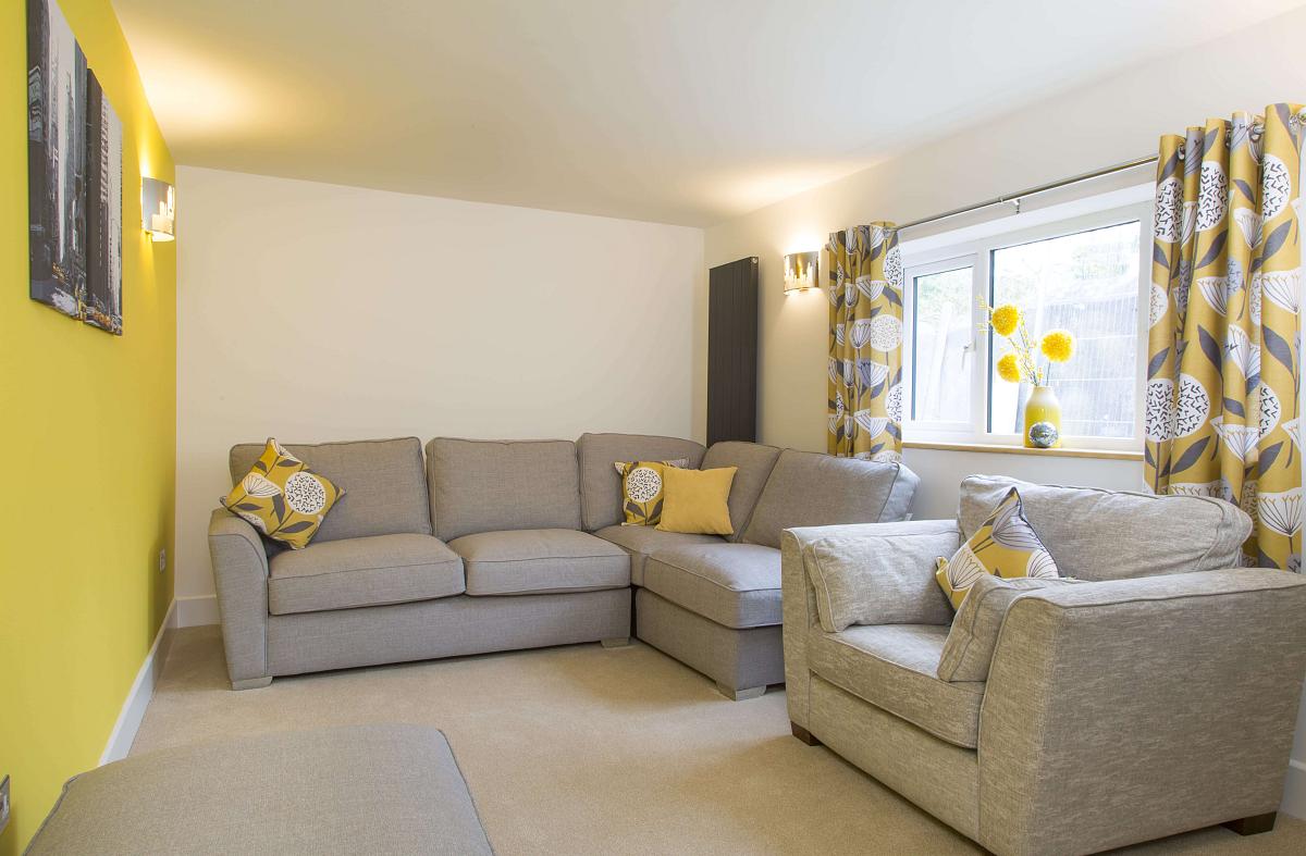 Shared living area with L shaped sofa and armchair