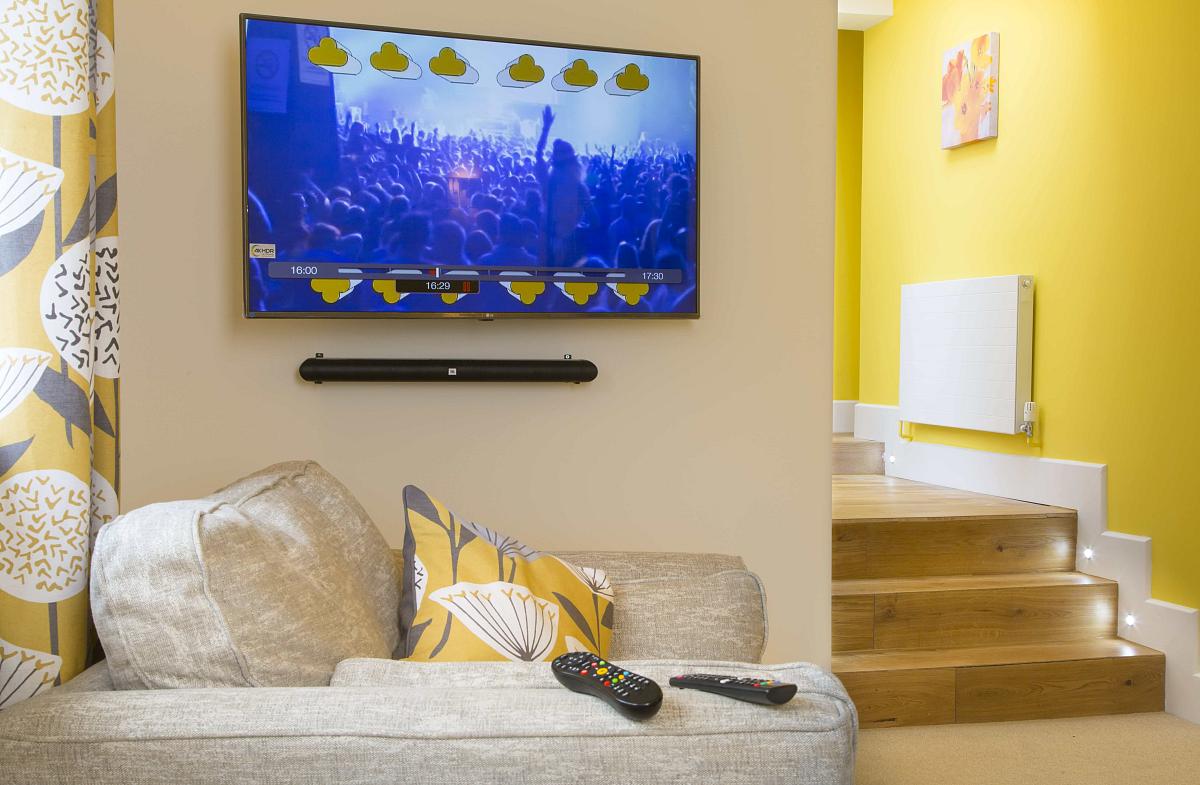 Shared living area with sofa and arm chair leading from shared kitchen