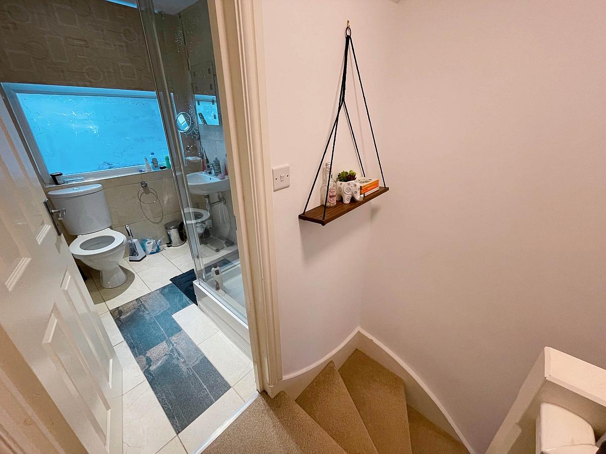 Stairs leading to shared bathroom with shower