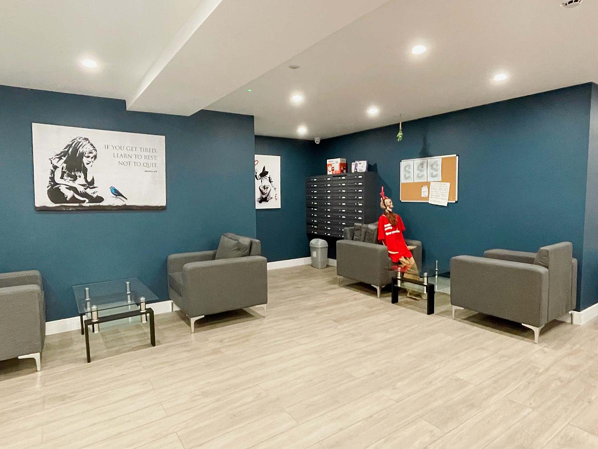 Downstairs communal area with separated flat letter boxes and arm chairs