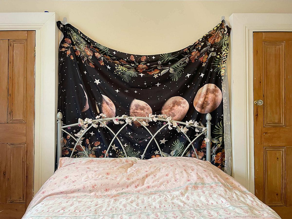 double bed with tapestry behind