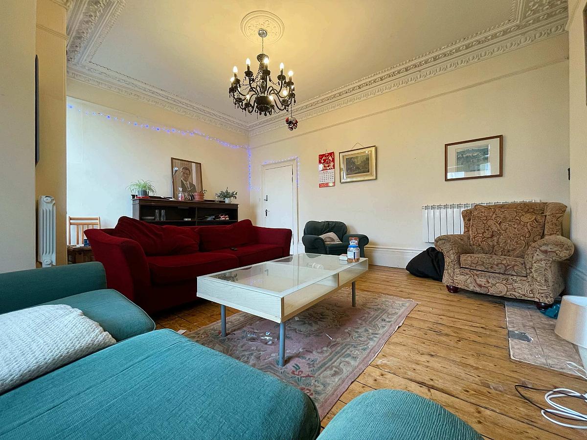 Large shared living room with two double sofas and two arm chairs