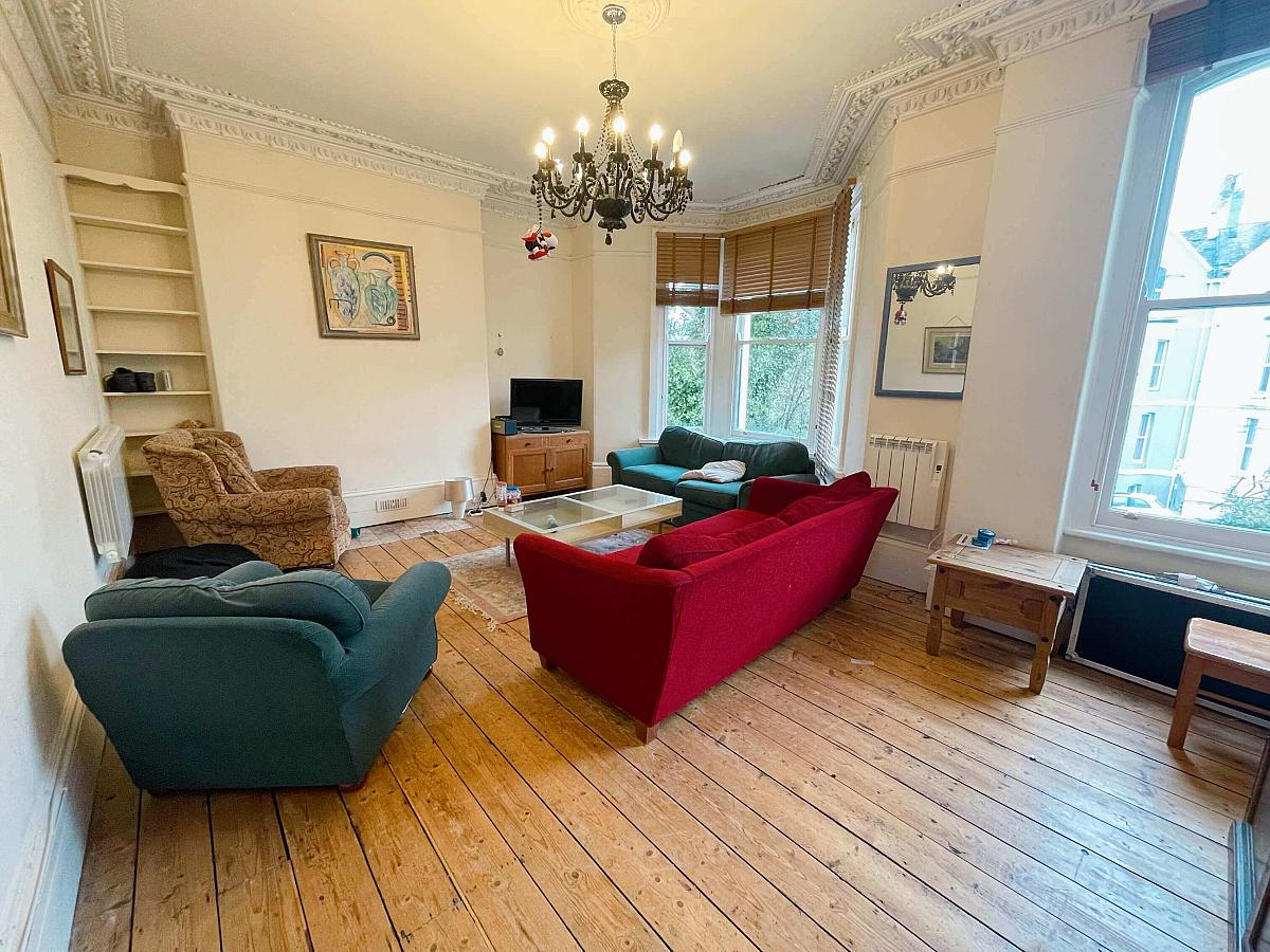Large shared living room with two double sofas and two arm chairs