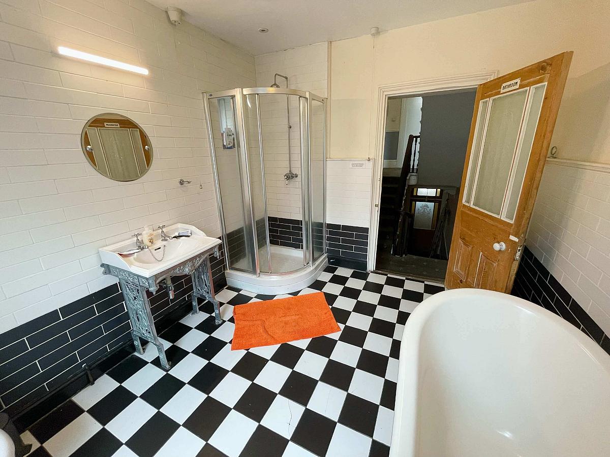 Shared bathroom with large bath and shower