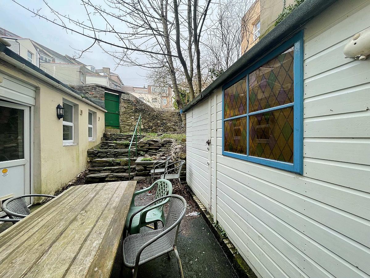 Shared back garden with outside seating leading to back gate