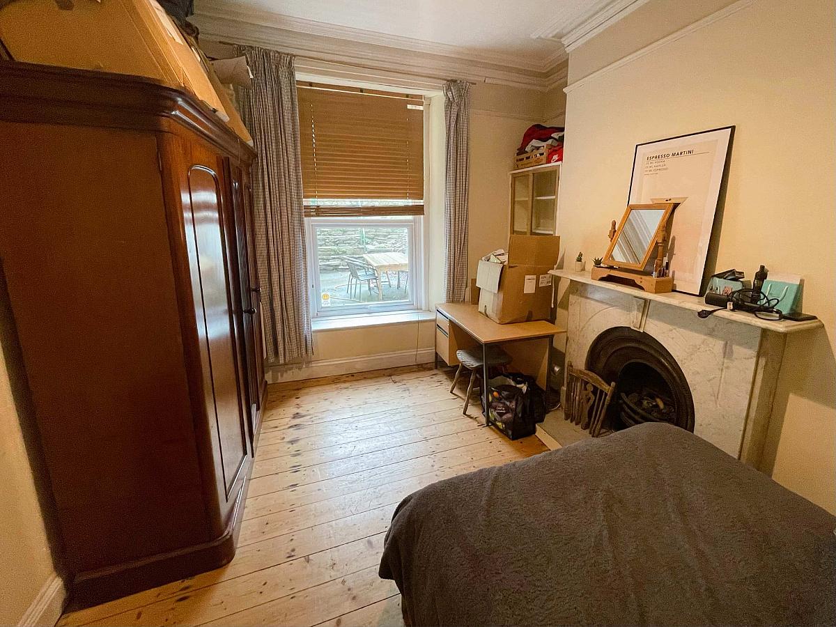 fifth student room with double bed, desk and wardrobe
