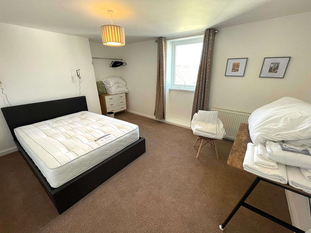 First student bedroom with double bed, chest of drawers, clothes rail and desk