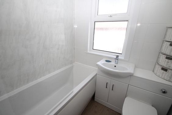 white shared bathroom with bath