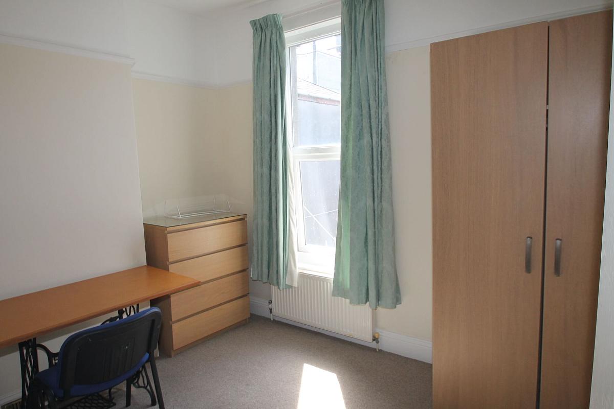 fourth student bedroom with double bed, two door wardrobe, chest of drawers and desk with blue chair