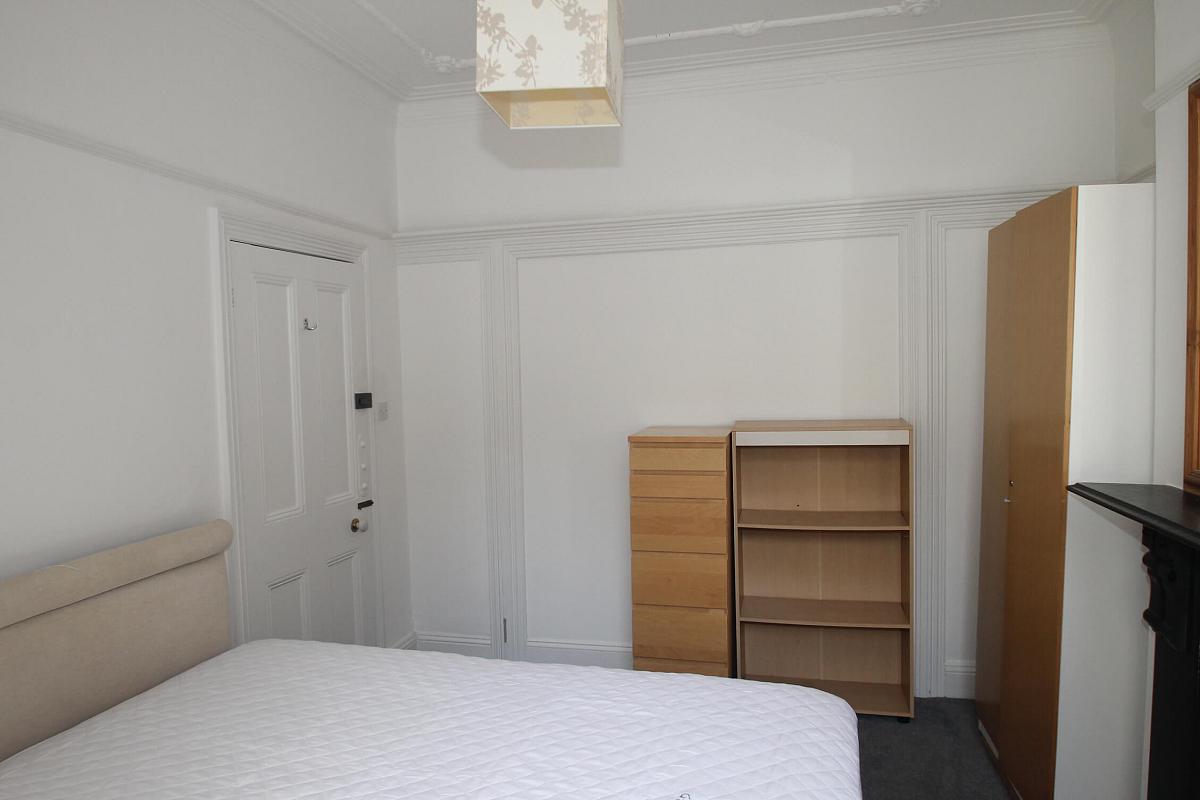 second student bedroom with double bed, two door wardrobe, tall chest of drawers and shelving unit