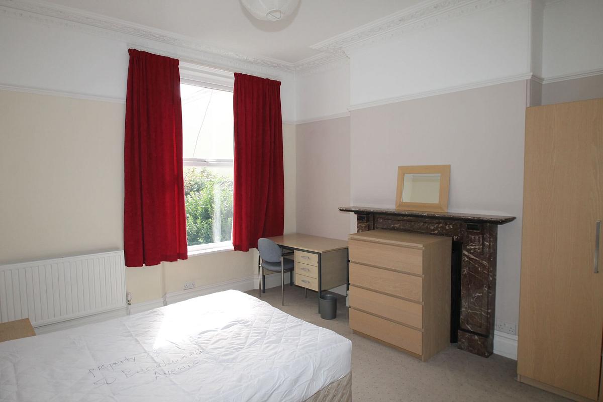 Second student bedroom with double bed, chest of drawers, two door wardrobe, desk with chair and bedside table