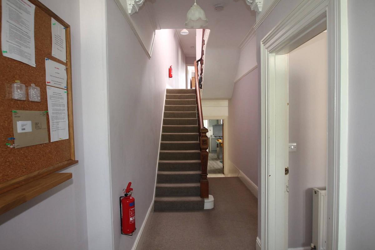 Hallway from the front door, showcasing entrance to living room, hallway leading to kitchen and dining area and stairs leading to first floor