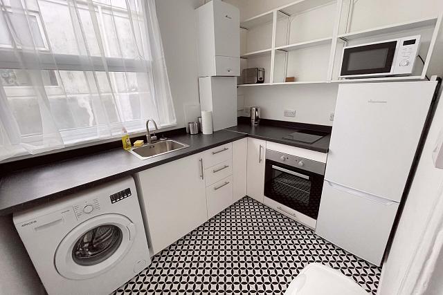 Kitchen with induction hob and cooker, washer/dryer and fridge freezer and sink