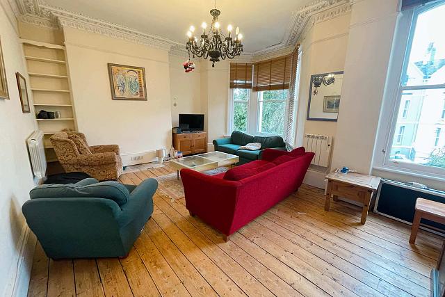 Large shared living room with two double sofas and two arm chairs